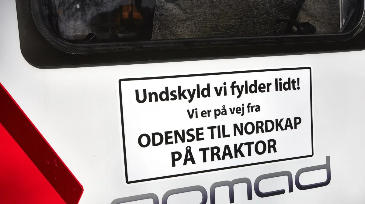 Med skiltet bag på campingvognen håber Allan Lyngsø på forståelse for parrets projekt fra medtrafikanterne på turen ad landevejene til Frederikshavn og videre op gennem Sverige, Finland og Norge. 