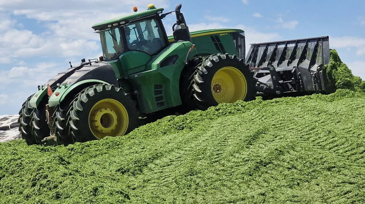 Det er én af ranchejer Lynn Burtenshaws fire sønner, der kører med John Deere 9520-traktoren med 572 hk på ensilagebjerget for at presse det hårdt sammen.