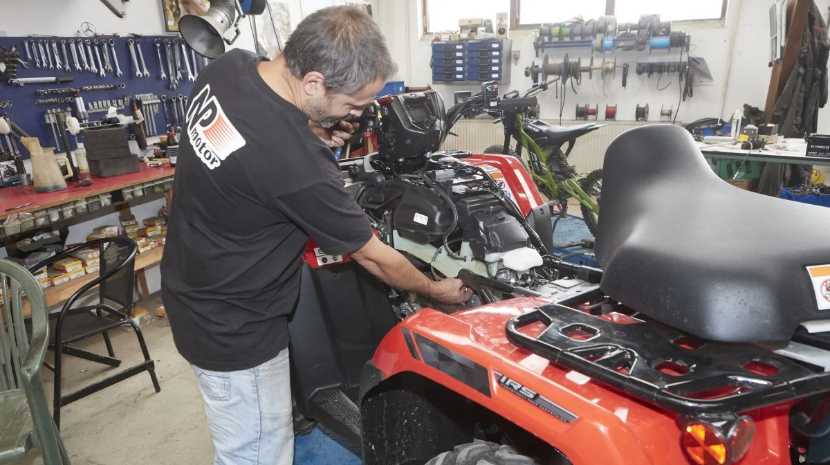 Det erfarne værkstedspersonale udfører service og reparationer af alle ATV-mærker. Her er værkfører Claus Dabros i gang med servicetjek af en ny Honda-model.