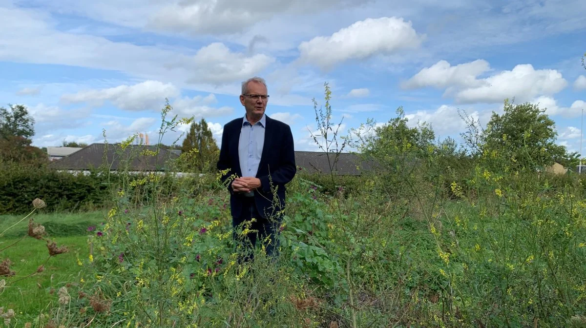 - Den måde, vi gør tingene på i Agrovi, tager ofte udgangspunkt i vores egne erfaringer, fortæller Niels Peter Ravnsborg - her i den »vilde Agrovi-have«, hvor taget på hovedsædet i Hillerød ses i baggrunden.