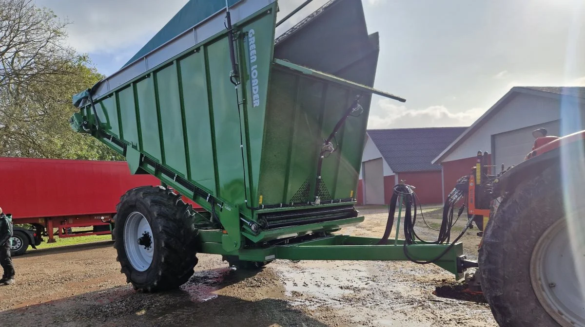 Når græsset er høstet, bliver det fragtet via denne greenloader, der separerer saft fra græsset, inden det hele kommer i lastbilen, der ses i baggrunden.