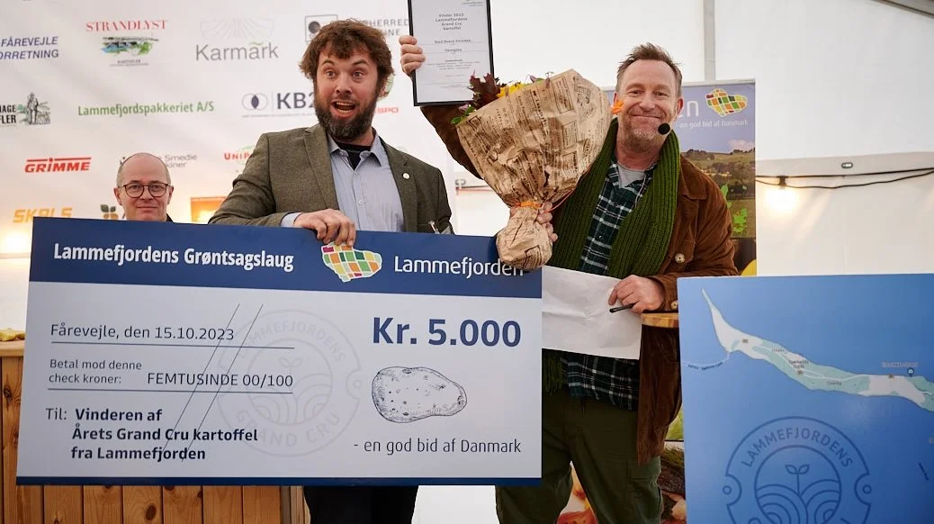 Emil Busch-Petersen var synligt begejstret over førstepladsen i kartoffel-finalen. Til højre konferencier Adam Price og til venstre en af dommerne, Sander Blohm. Foto: Peter Jarvad 