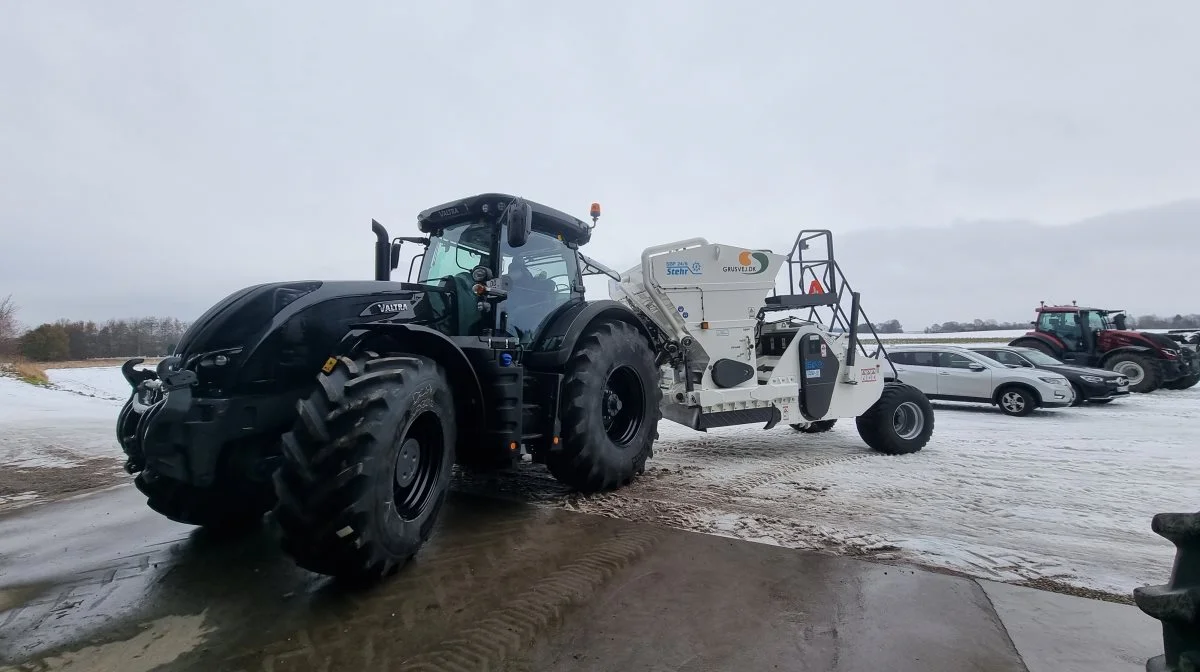 Den kraftfulde traktor forlader lagerhallen og køres ud foran maskinforretningen.