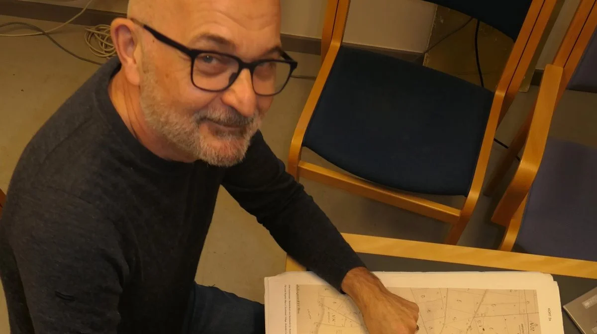 Professor Mogens Greve viser her på et gammelt kort, hvordan det gamle dyrkningssystem med indmark og udmark omkring landsbyerne øgede mængden af organisk materiale i indmarksjorden, fordi der hvert år blev tilført organisk materiale fra udmarken. Foto: Bøje Østerlund