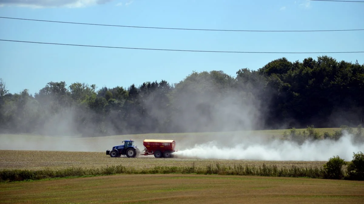 Den hvide støvsky bag kalksprederen kan snart blive sort. Med en øget produktion og dermed tilførsel af biokul til landbrugsjorden, kan behovet for kalktildeling reduceres. Foto: Camilla Bønløkke