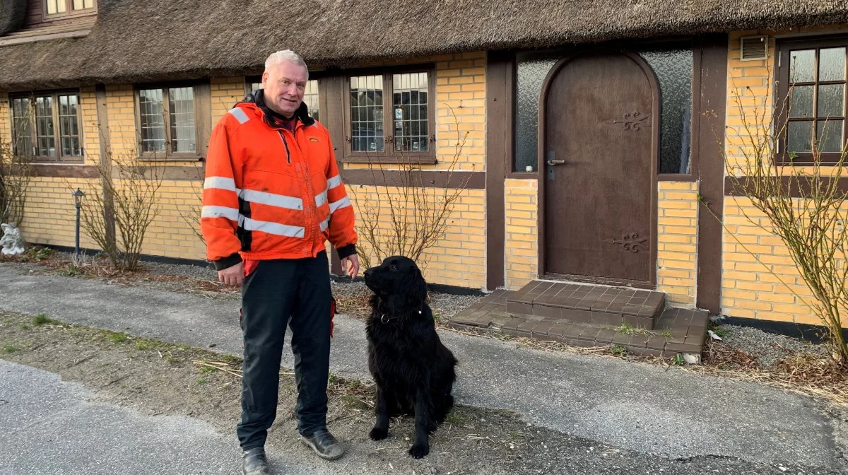 63-årige Birger Niemann og flat-coated retrieveren Fido foran den gamle hoveddør på Tolstrupgaard, der alle årene har været base for maskinstationen. Foto: Jesper Hallgren