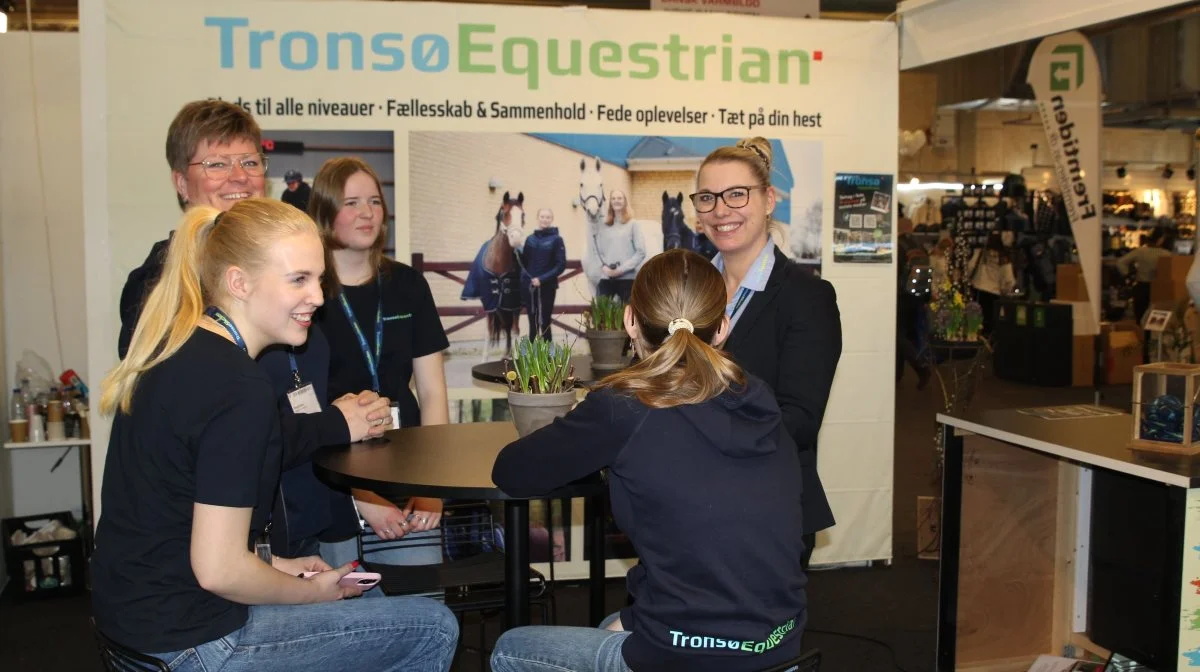 Stine Steffensen, afdelingsleder Tronsø Equestrian (stående th) sammen med lærer og elever på Tronsø Efterskole på stand ved Hest & Rytter-messen i Herning. Foto: Henriette Lemvig