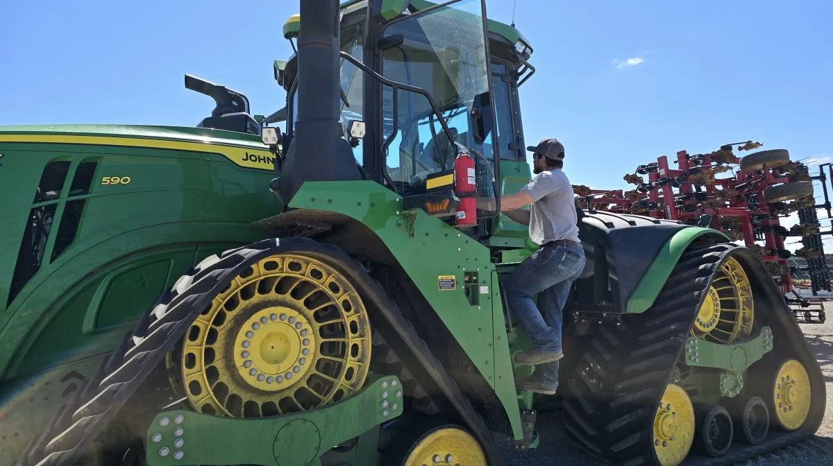 Kyle Eike på vej op i en af farmens i alt ni John Deere 590-bæltetraktorer.