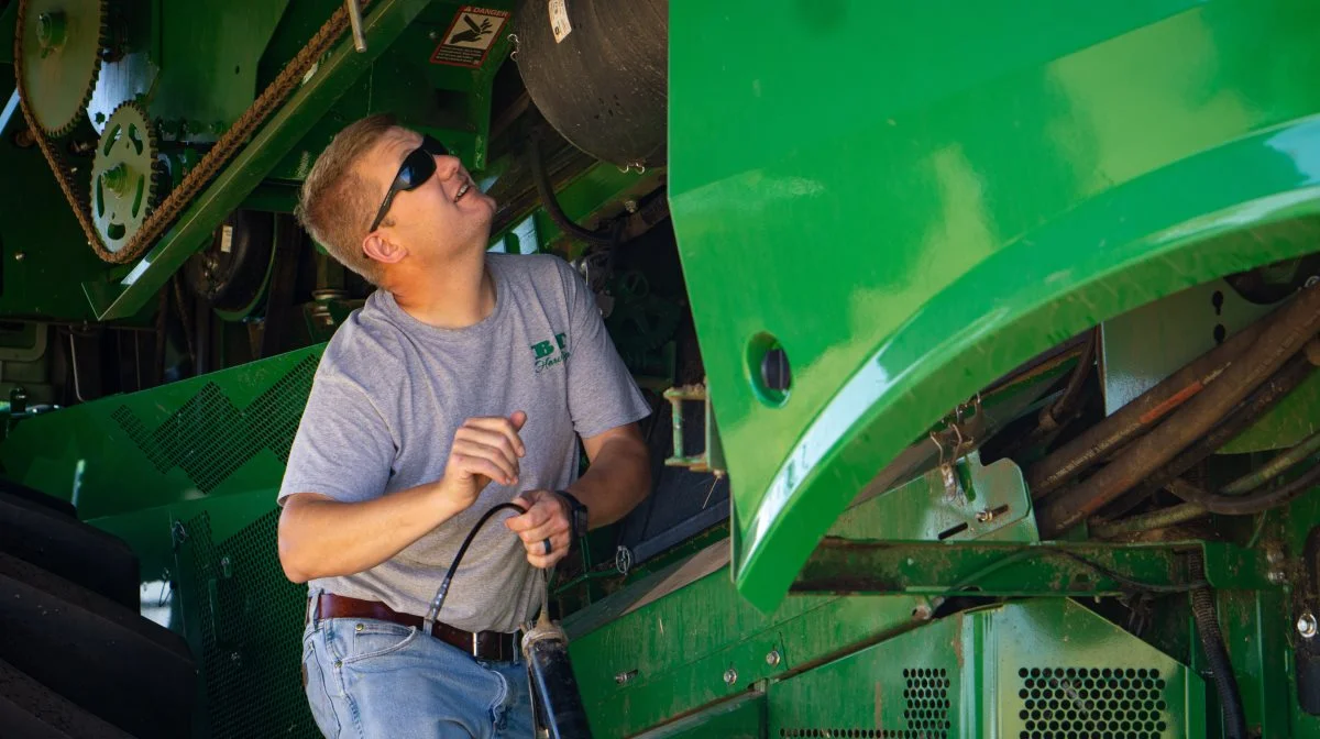 Selv om der udelukkende køres med helt nye John Deere-mejetærskere med kun 14 dages høst bag sig, skal de naturligvis serviceres - her er Anders Buus Thomsen selv i gang med smøringen. Fotos: Daniel Barber