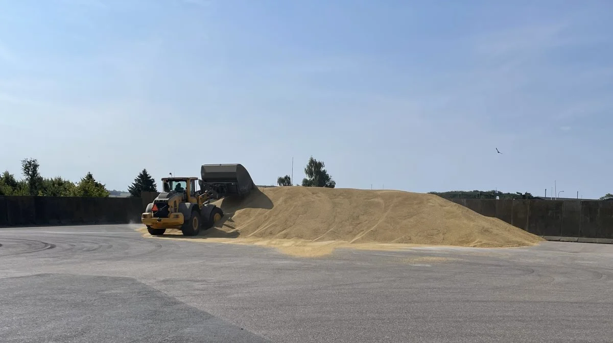 Driftsmedarbejder Erik Møller Jensen er hoppet en tur op i gummigeden og er ved at skubbe op i bunken med byg.