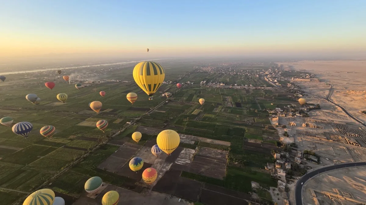 Effektivt Landbrugs udsendte er kommet højt op i en luftballon for at se solopgangen over Nilen (tv). Her ses tydeligt, at det opdyrkede land slutter brat ved ørkenen cirka 10 kilometer fra floden.