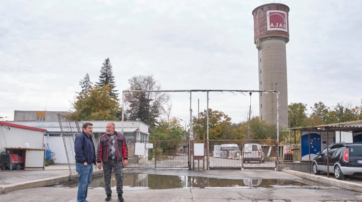 Petar Ivanov og en medarbejder ved indgangen til en af farmene, som har eget vandtårn.