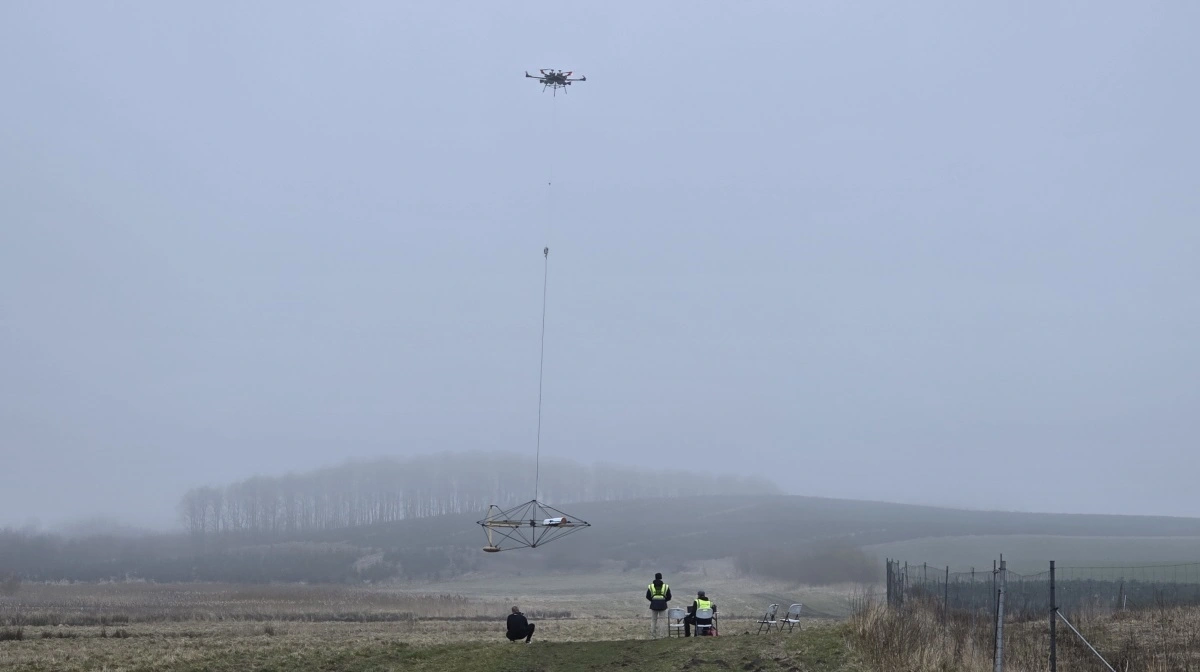 Under den store drone hænger tæt over jorden det stativ, hvorfra særlige gammasensorer »ser« ned gennem jordlagene og leverer data til at tegne et 3D-kort over jordbundens sammensætning. Fotos: Jørgen P. Jensen 