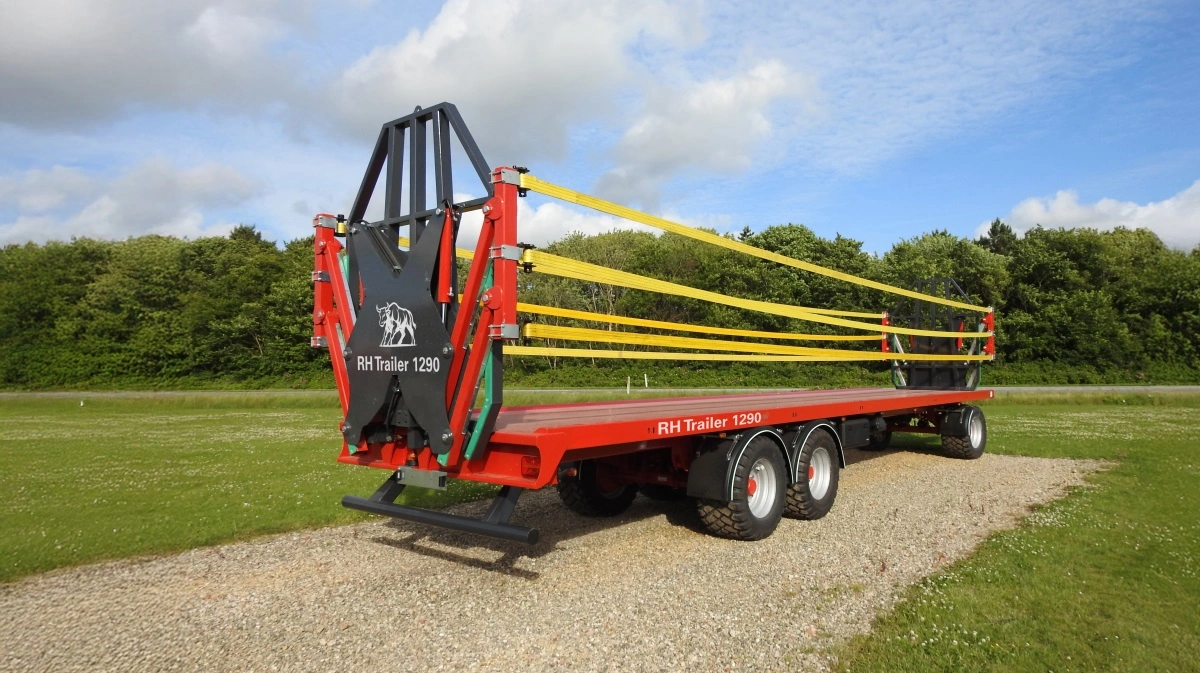 RH Trailer DK 1290 er den længste af de tre nye modeller i serien og har en ladflade på 12,9 meter. Her er den vist med påmonteret front- og bagrækværk samt hydraulisk lastsikring, der består af tre kraftige bånd i hver side. Systemet kører ned, når halmen læsses, og løftes op igen for at sikre læsset under kørsel. Pressefoto