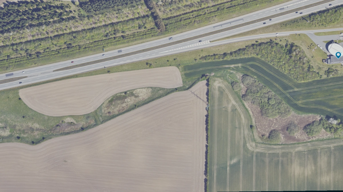 Mosen, der ses til venstre på billedet, ligger ved Esbjergmotorvejen nær rastepladsen Harte Syd (th). Billedet er taget i 2023. Foto: Skraafoto/Klimadatastyrelsen