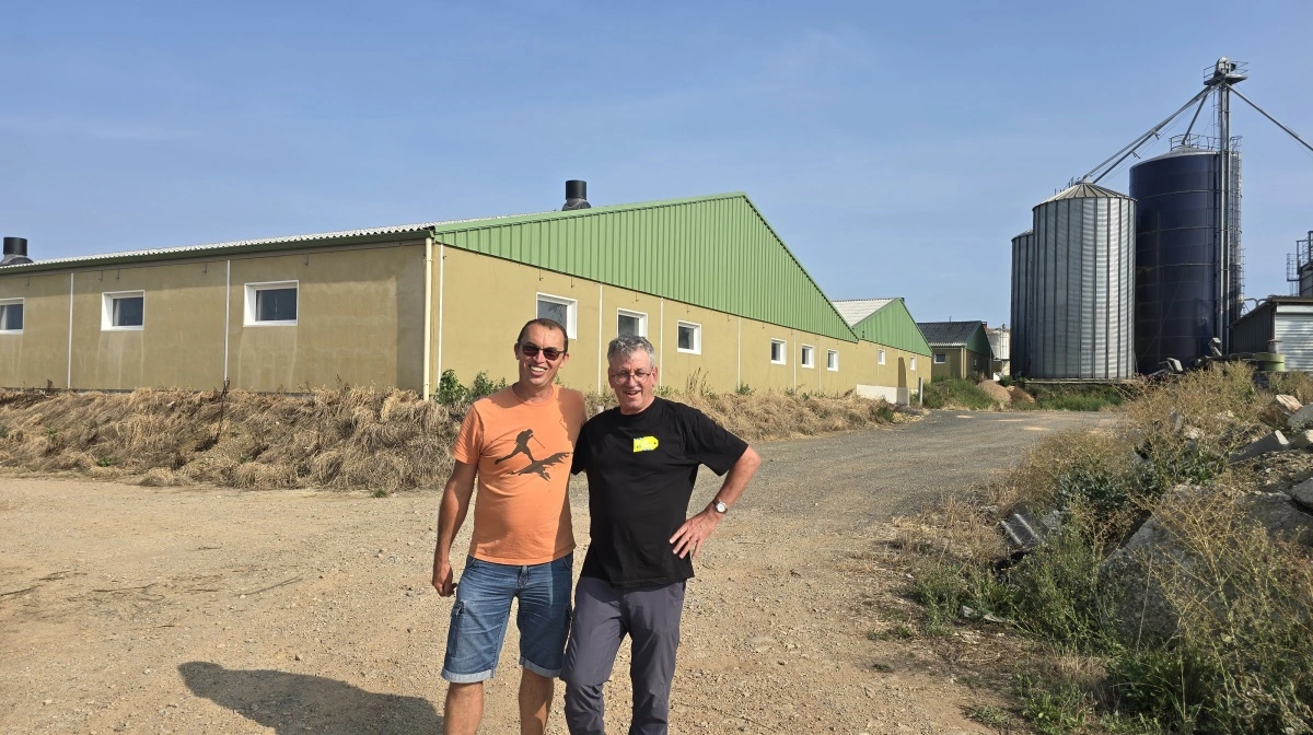 Nicolas Denieul sammen med Jean-Marie Poirier, der formidler unge landmænd i praktik, foran de nyistandsatte grisestalde, der blev opført efter brand i 2022.