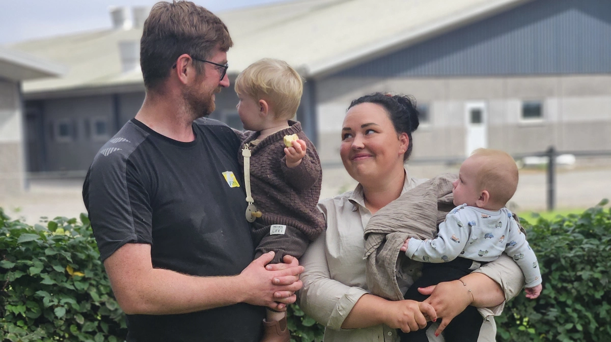 Rasmus Blem Kofoed med kæresten Emilie og deres to sønner, Eskild på 17 måneder og Edvard på 6 måneder. I baggrunden slagtesvinestalden med 4.000 stipladser.