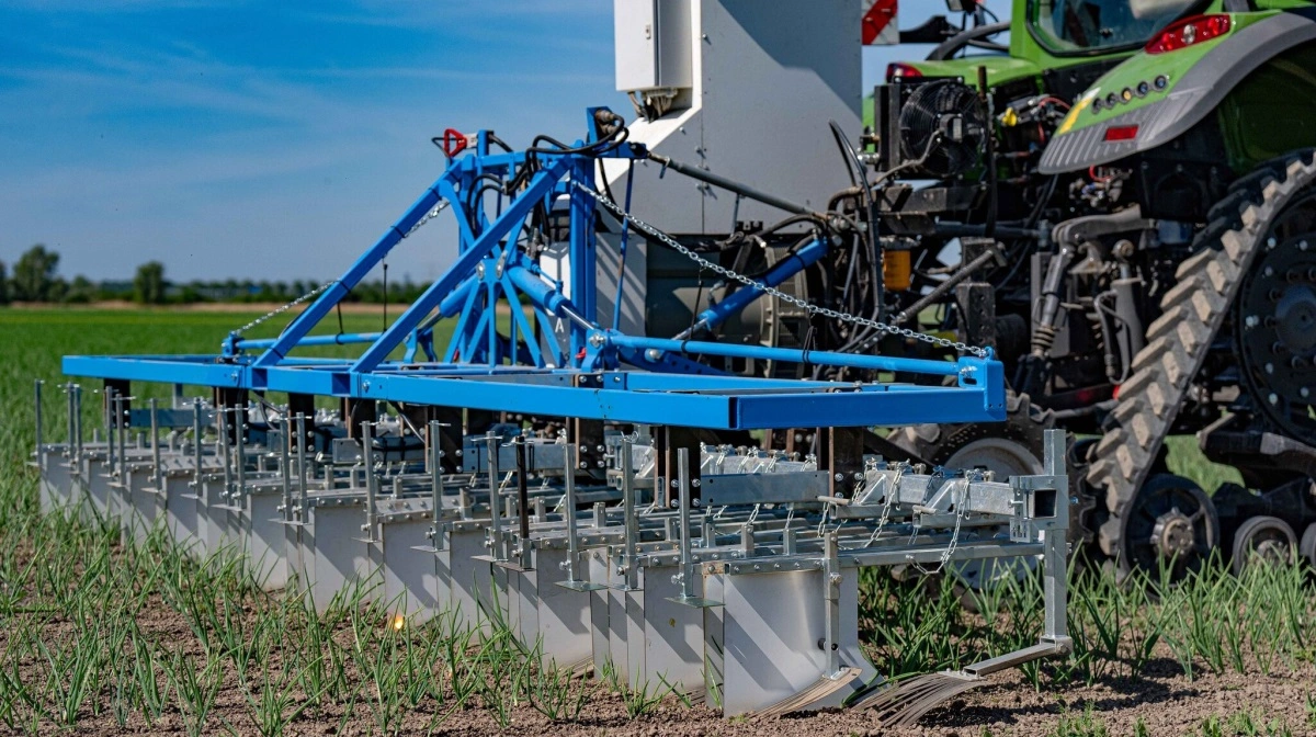 Den første Andela Electric Weeder er allerede sat i arbejde på danske marker. Maskinen drives af en PTO-generator og leder strøm ud til brede kontaktplader, som rammer ukrudtet direkte i vævets ledningsbaner. Dermed ødelægges planten indefra uden at påvirke kulturplanterne omkring den. Pressefotos