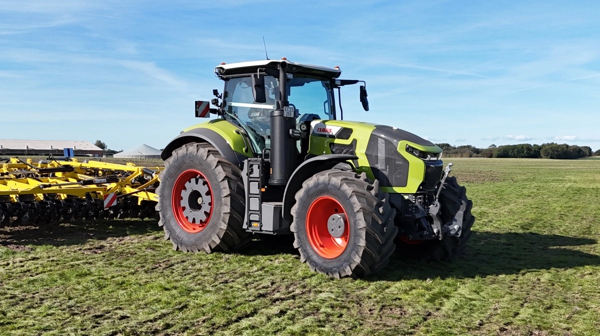 Axion 9-serien fås også i klassisk hjulversion, her i tungt trækarbejde med harve. Lang akselafstand, lavt tyngdepunkt og 50/50-vægtfordeling på for- og bagaksel er en del af Claas’ DNA for maksimal trækkraft og stabilitet. De nye modeller kan udstyres med dobbelt hydraulikpumpe på op til 370 l/min. og leverer kraft til de mest krævende redskaber i marken.