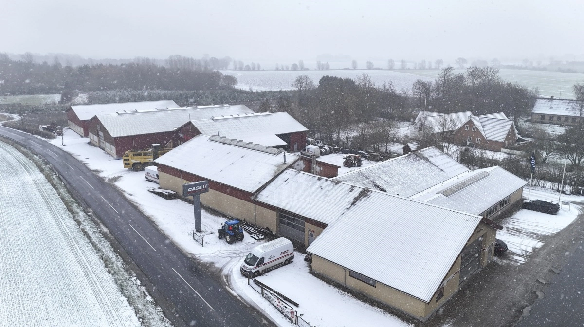 Midt i den frodige landbrugsjord på Stevns ligger Frøslev Maskinforretning. Der rådes over 3.300 kvadratmeter, hvor seneste udbygning er den 500 kvadratmeter koldhal bagest. Forrest ved vejkrydset lå den oprindelige landsbysmedje, hvor det hele startede i 1900. Fotos: Erik Hansen