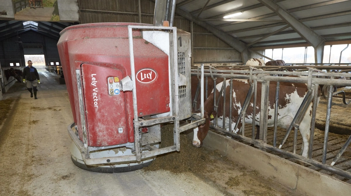 Sammen med fodermester Jesper Jensen (i baggrunden), som har været på Aalegaarden i 23 år, passer Anne Kathrine og Johan Bebe selv bedriften med 200 røde køer - godt hjulpet af moderne robotteknologi. Blandt andet denne Lely Vector foderrobot, som selv læsser, blander og udfodrer syv forskellige blandinger til køerne døgnet rundt. 