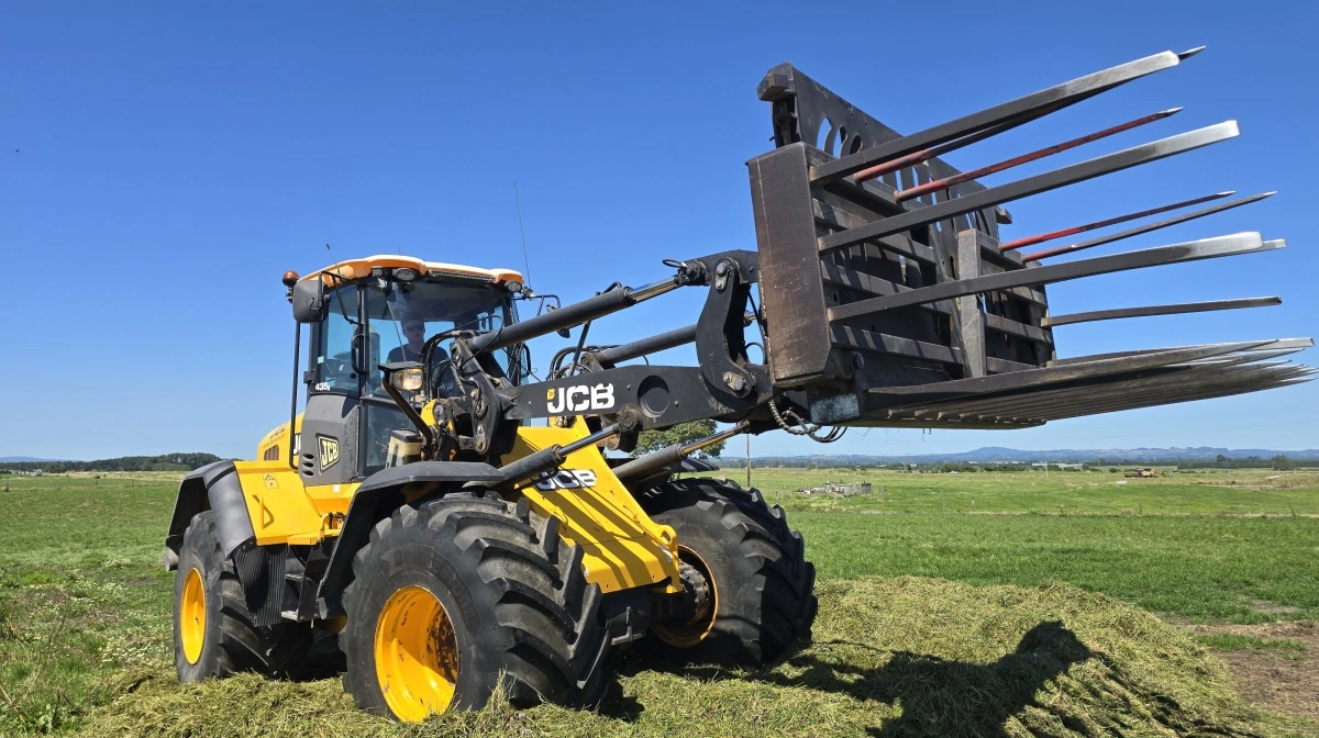 Emil er dagen igennem travl med at forme og sammenpresse den voksende ensilagestak af græs.