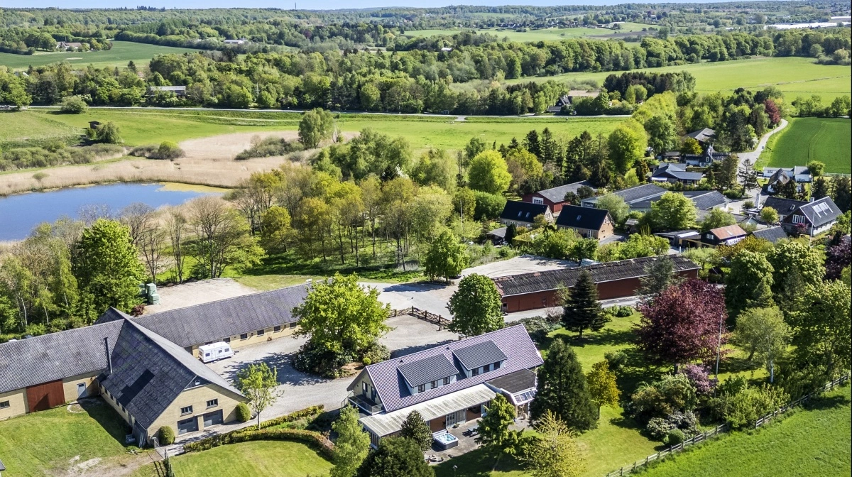 Ejendommen rummer både stuehus, driftsbygninger og et naturskønt område med blandt andet sø og grønne arealer, som understøtter den miljøvenlige profil.