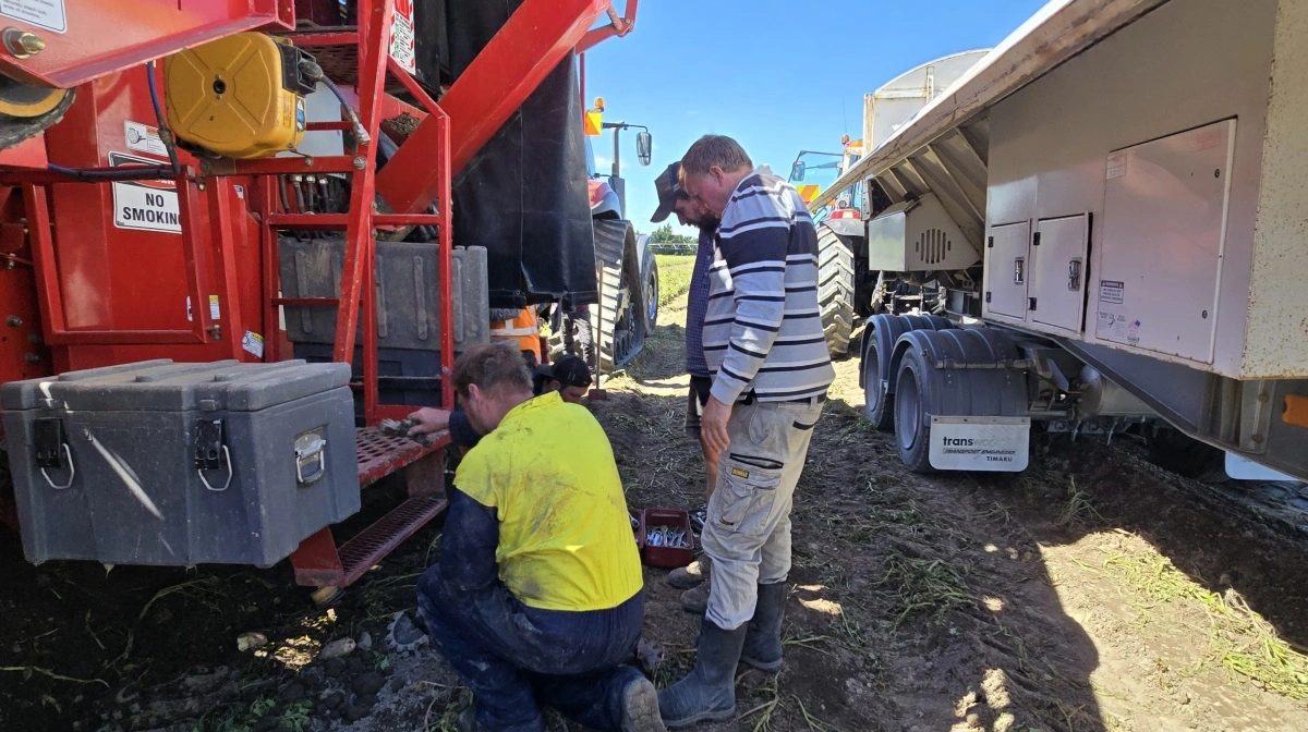 Ross Hewson (i stribet trøje) vurderer maskinstoppet med servicefirmaet.
.