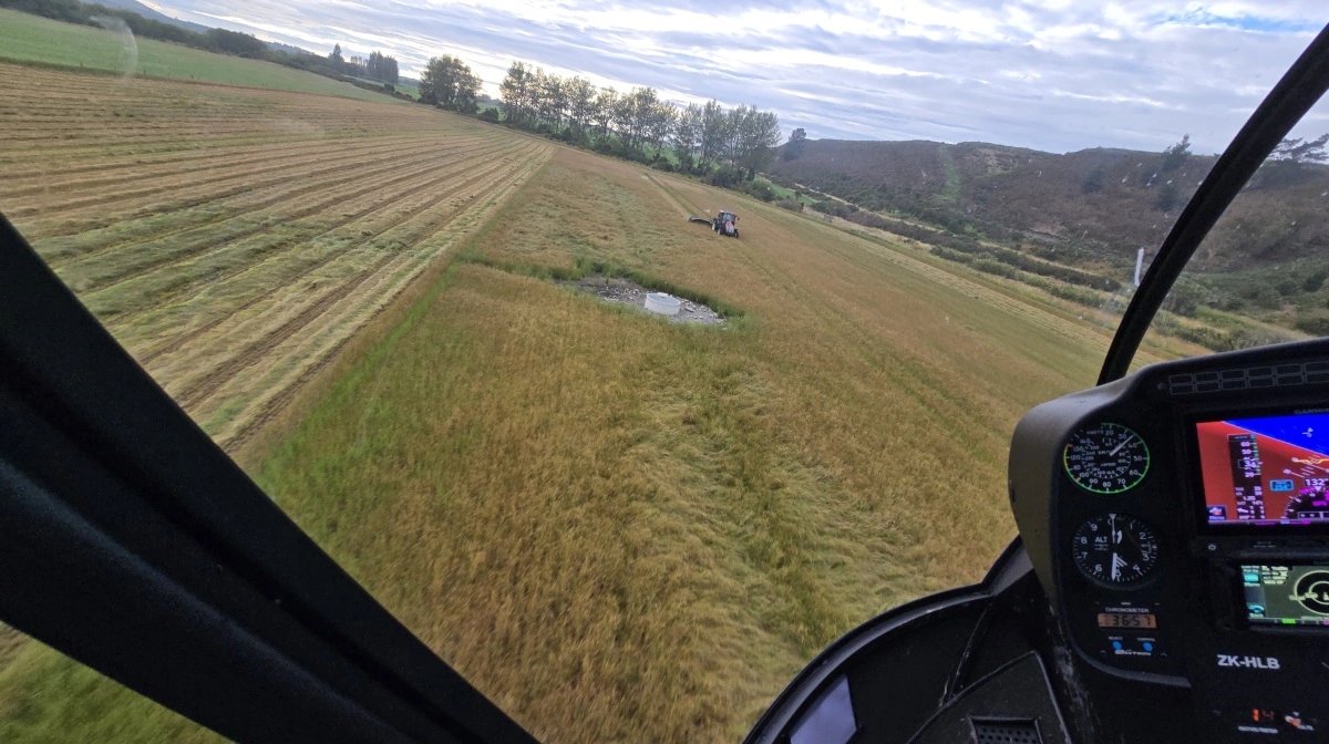 Naboen i traktoren får for sjov helikopteren helt ned over traktoren.