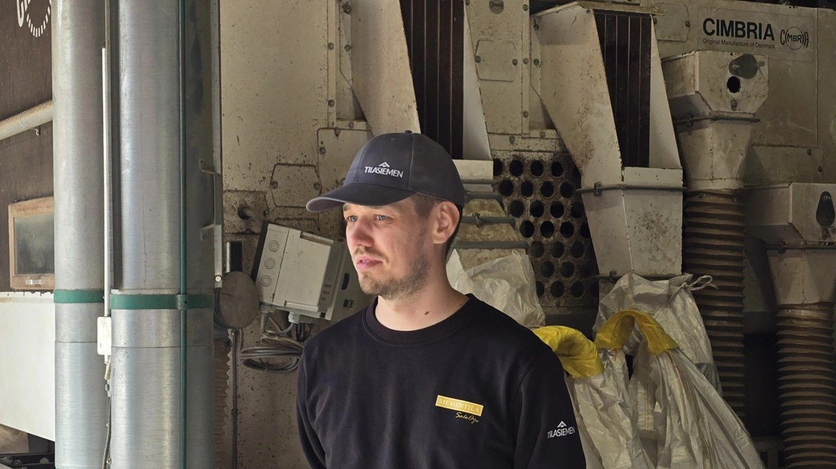 Niilo Salo fortæller om gårdens tørreri, der - som det ses i baggrunden - er fra danske Cimbria med hovedkontor i Thisted.