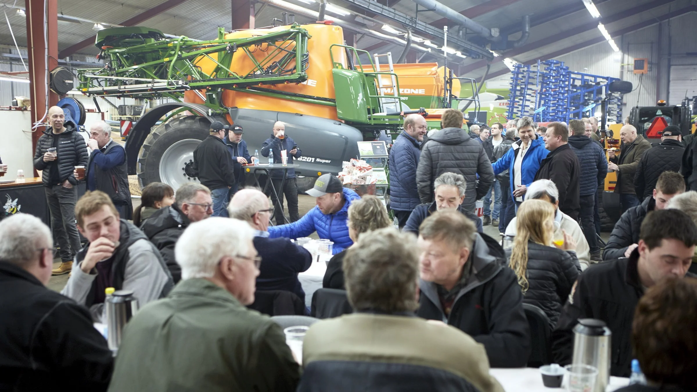 Ikke mindre end 1.400 besøgte åbent hus-dagen i Ringe Maskinforretning, hvor der traditionen tro blev serveret pølser og fadøl i værkstedet blandt de mange maskiner. Til venstre sidste års Amazone sprøjte-nyhed model UX 6201, hvor dette første eksemplar allerede er solgt på Fyn.

