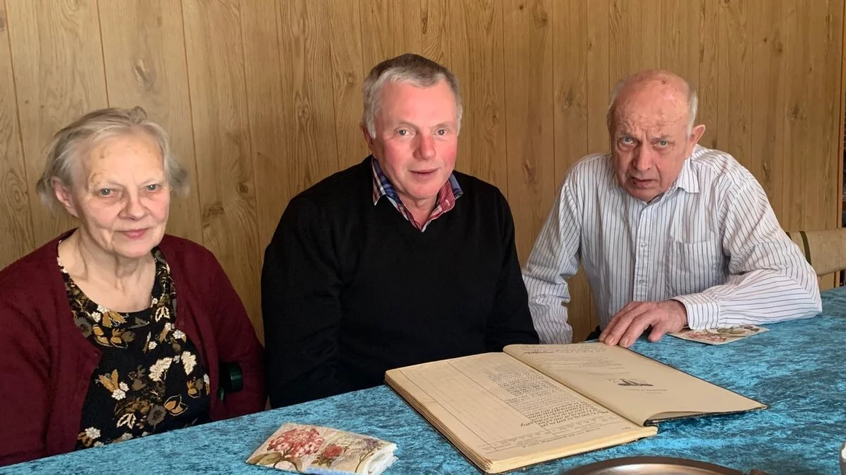 Rita og Flemming Larsen sammen med Barrit Mejeris formand, Bent Pedersen (i midten), der takkede dem for lang og tro tjeneste som leverandører.  Foran dem en gammel familiestambog, hvor man kan finde oplysninger om køerne helt tilbage fra 1945. Fotos: Lene Tingleff, LET Kommunikation