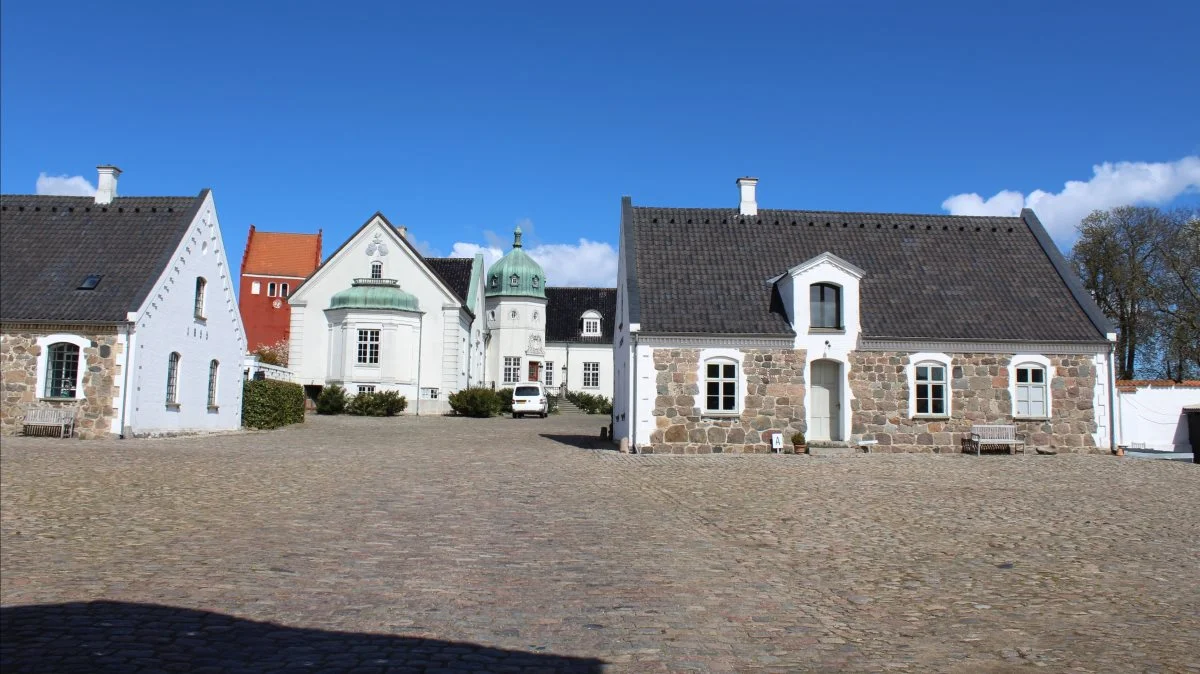 Hørbygaard Gods ligger på Tuse Næs, der er en halvø nord for Holbæk. I baggrunden ses den lokale kirke. 