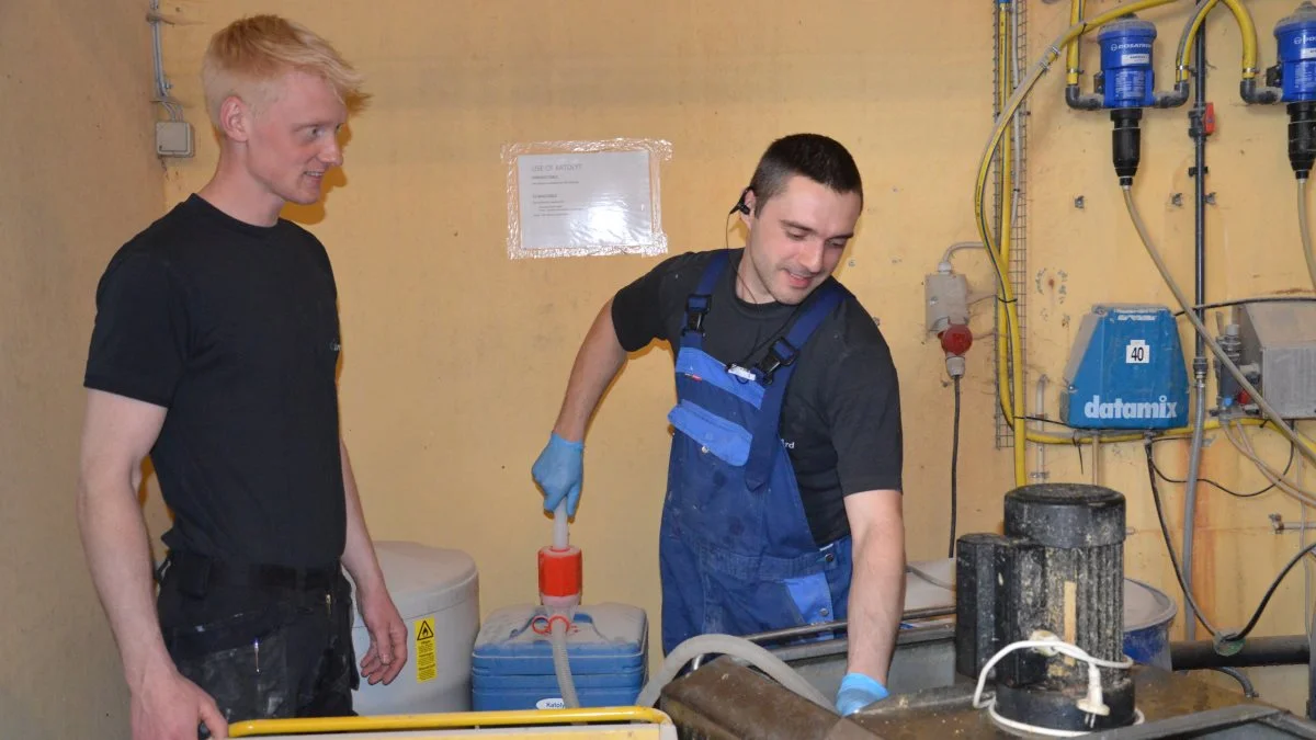 Med vandanlægget får man sammen med en stabil vandkvalitet og rene vandrør uden biofilm også et brugbart biprodukt, der kan anvendes i stedet for andre desinfektionsmidler til rengøring i stalden. Her er det Demi (th) der er ved at tappe fra tanken.