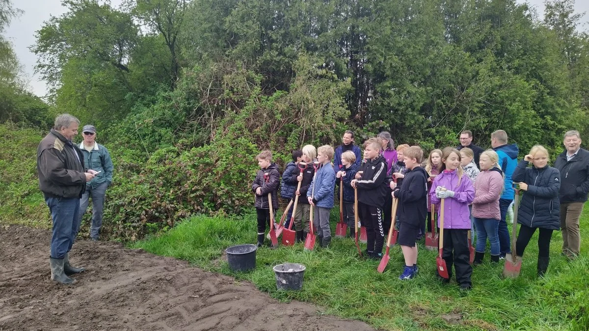 Formanden for Teknik, Miljø og Ejendomsudvalget, Peter Bring-Larsen, holder velkomsttale i forbindelse med etableringen af Eskilstrup folkeskov. mens eleverne fra byens skole lytter med.