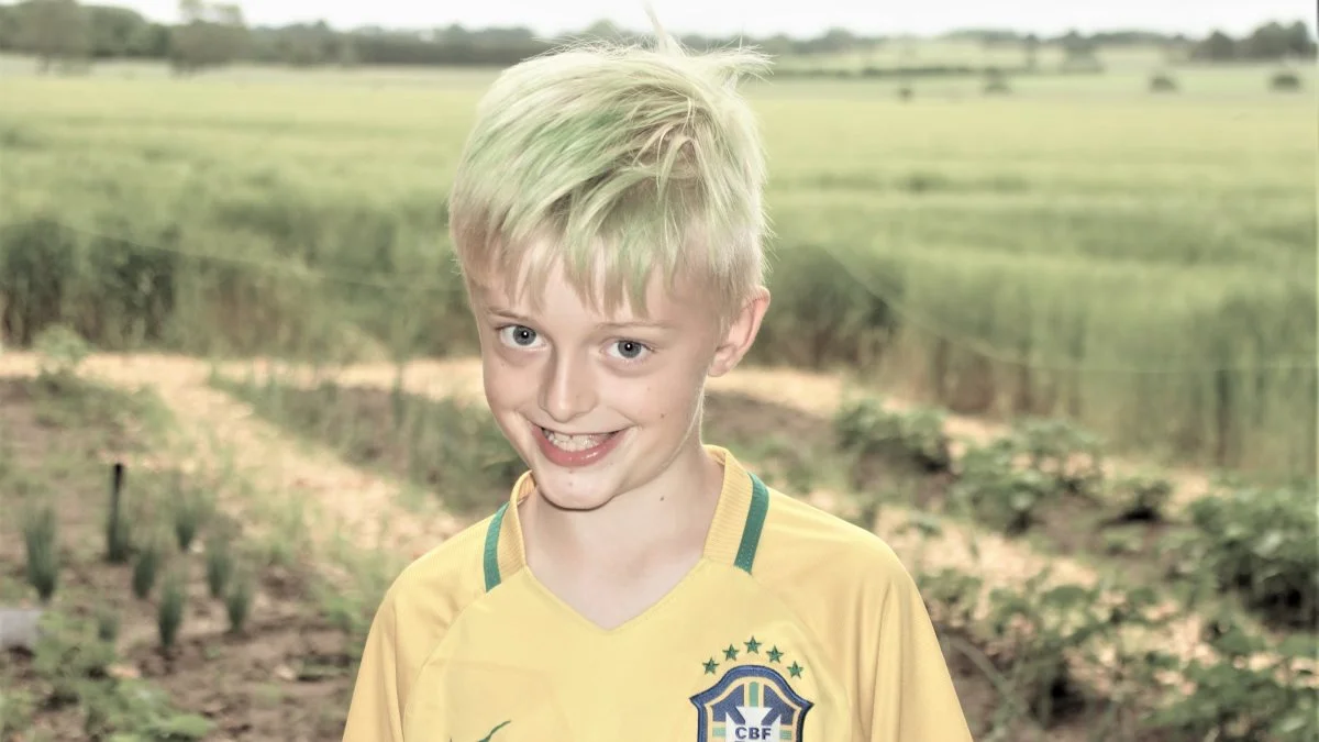 Lucas Mandrup fra Toubroskolen viste hellere end gerne rundt i skolens nye fælleshave, som er blevet til med hjælp fra Djursland Landboforening. Foto: Djursland Landboforening.