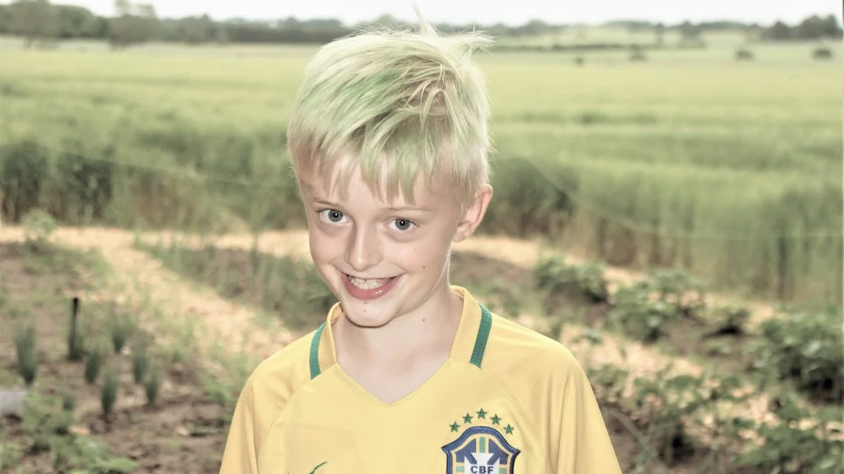 Lucas Mandrup fra Toubroskolen viste hellere end gerne rundt i skolens nye fælleshave, som er blevet til med hjælp fra Djursland Landboforening. Foto: Djursland Landboforening.
