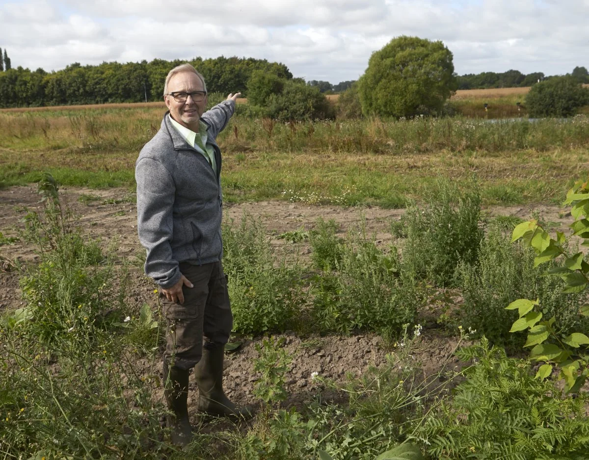 Skovfoged Børge Nissen glæder sig over den nye mulighed for klimaskov, som gerne skulle udmønte sig i endnu mere ny skov og naturområder i landskabet. Egetræet foran ham i den kommende skov er plantet sidste år, og i baggrunden ses en skov ved Kølstrup, som han var med til at etablere for 21 år siden.