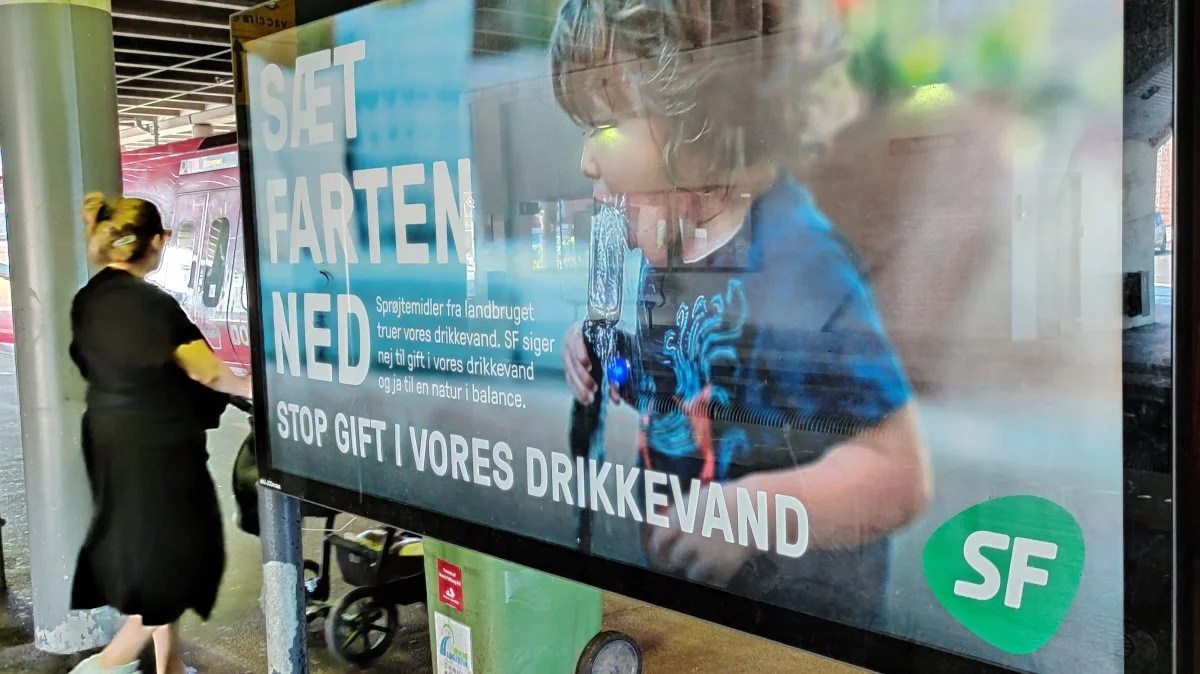"Stop gift i vores drikkevand",  lyder det på store plakater på togstationer. Landbruget får på plakaten skylden. 
