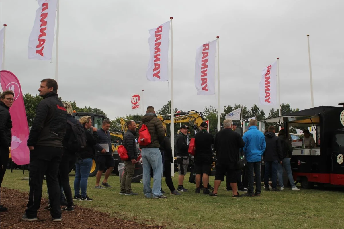 Der var ind imellem meget lange køer til madboderne. Her har de sultne gæster god tid til at kigge på Yanmar-maskiner fra Maskiner A/S. Foto: Jesper Hallgren