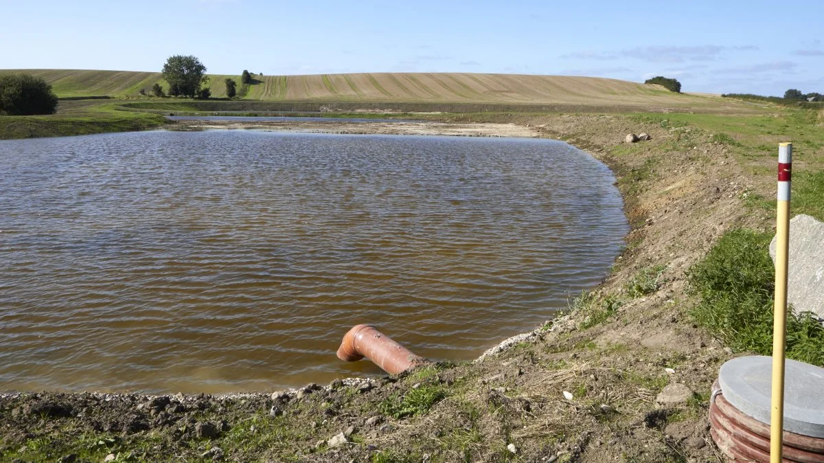 Efter drænvandet har passeret de tre bassiner, hvori der er forskellige dybder ledes det gennem det skråtstillede afløb videre ud til Bøgebjerg Strand. Bemærk det høje bakkedrag, der er en del af det 90 hektar opland til minivådområdet.