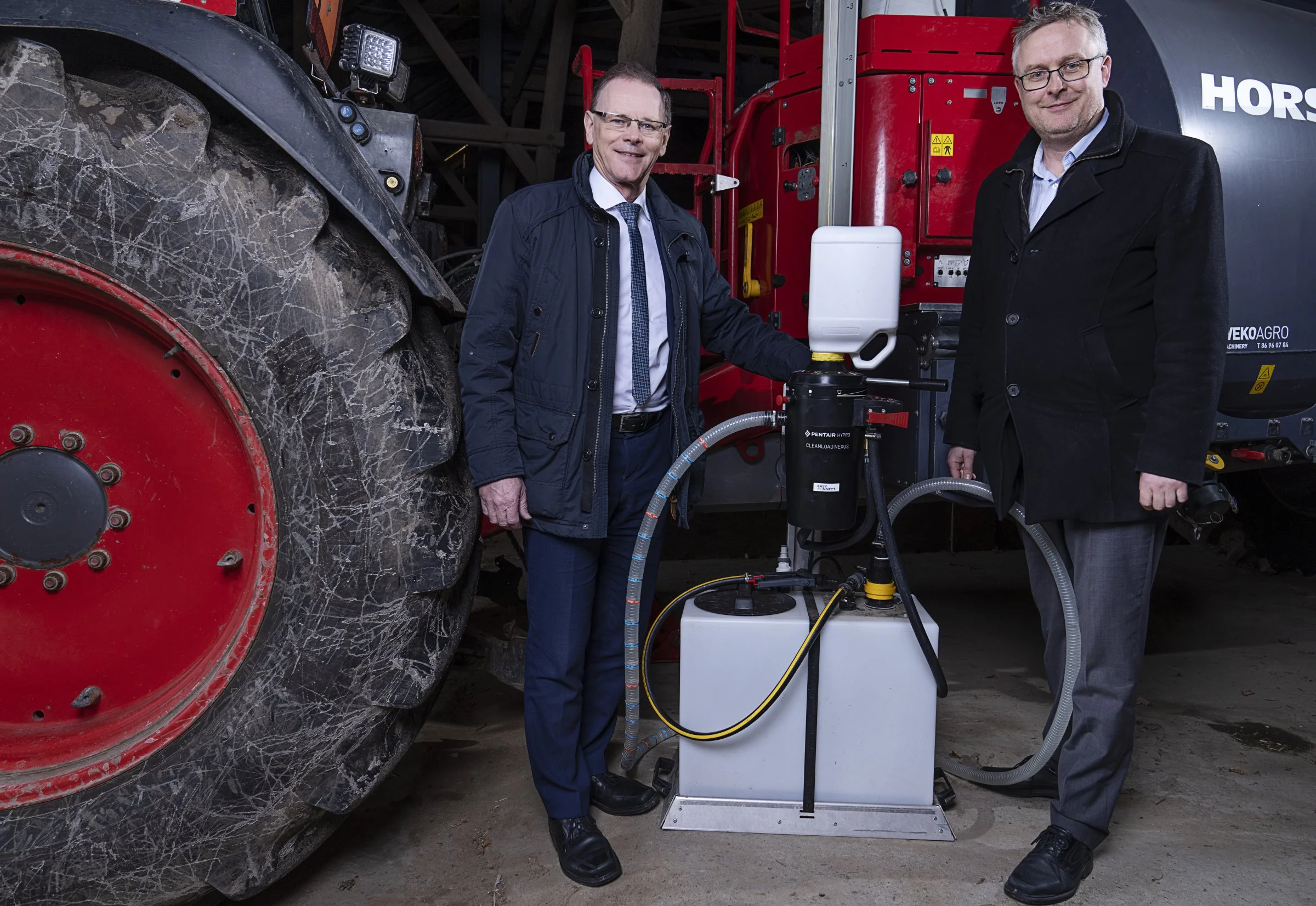 Landbrugsordfører Erling Bonnesen og miljøordfører Jacob Jensen - begge fra Venstre - ved det lukkede påfyldningssystem Easyconnect, som kan være et middel til at reducere pesticidbelastningen. Foto: Claus Bech