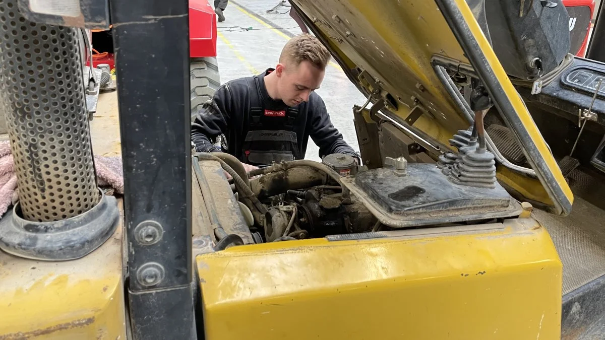 Lærling Casper Møller Kristensen fuldt koncentreret i serviceringen af en truck.