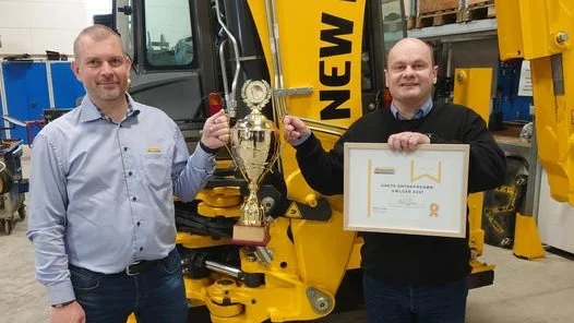New Holland Construction Danmark har udnævnt Niels Hansen (til højre) som Årets Entreprenørsælger 2021, og det indbragte diplom og vandrepokal, som blev overrakt af Martin Tornøe fra New Holland Construction. Foto: Johs. Mertz A/S