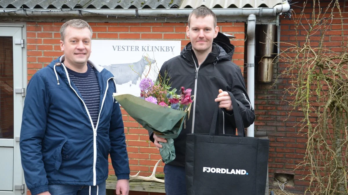 Morten Agger overrakte Damgaards Legat til Jeppe Skovgaard foran gårdskiltet med foto af en af de køer, som har hentet ærespræmier hjem til Vester Klinkby. Fotos: Fjordland