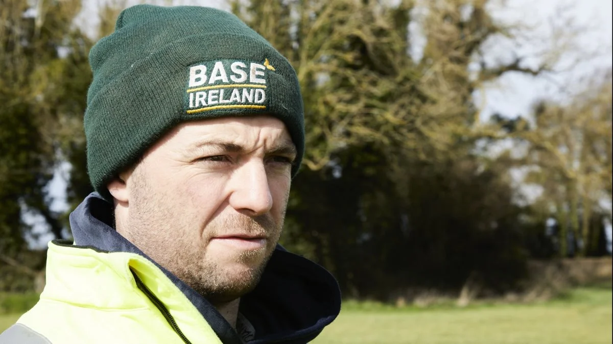 Base Ireland - som det står på Louis McAuleys hue - er en organisation for landmænd og forsøgsfolk, der arbejder med conservation agriculture.