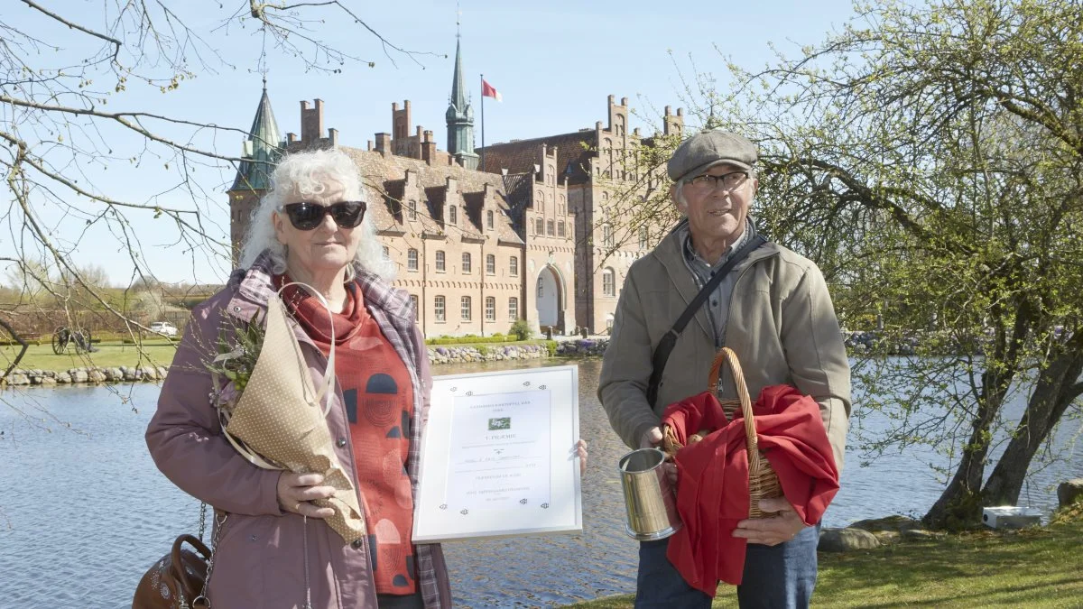I de smukke omgivelser på Egeskov Slot står årets danske mestre i dyrkning af frilandskartofler, Kaja og Aksel Sørensen, Jegerup, med præmiechecken på 4.000 kroner, blomster og kurven med vinterkartoflerne, som efter vejningen i hast blev fragtet til Hendes Majestæt Dronning Margrethe på Fredensborg Slot. Foto: Erik Hansen