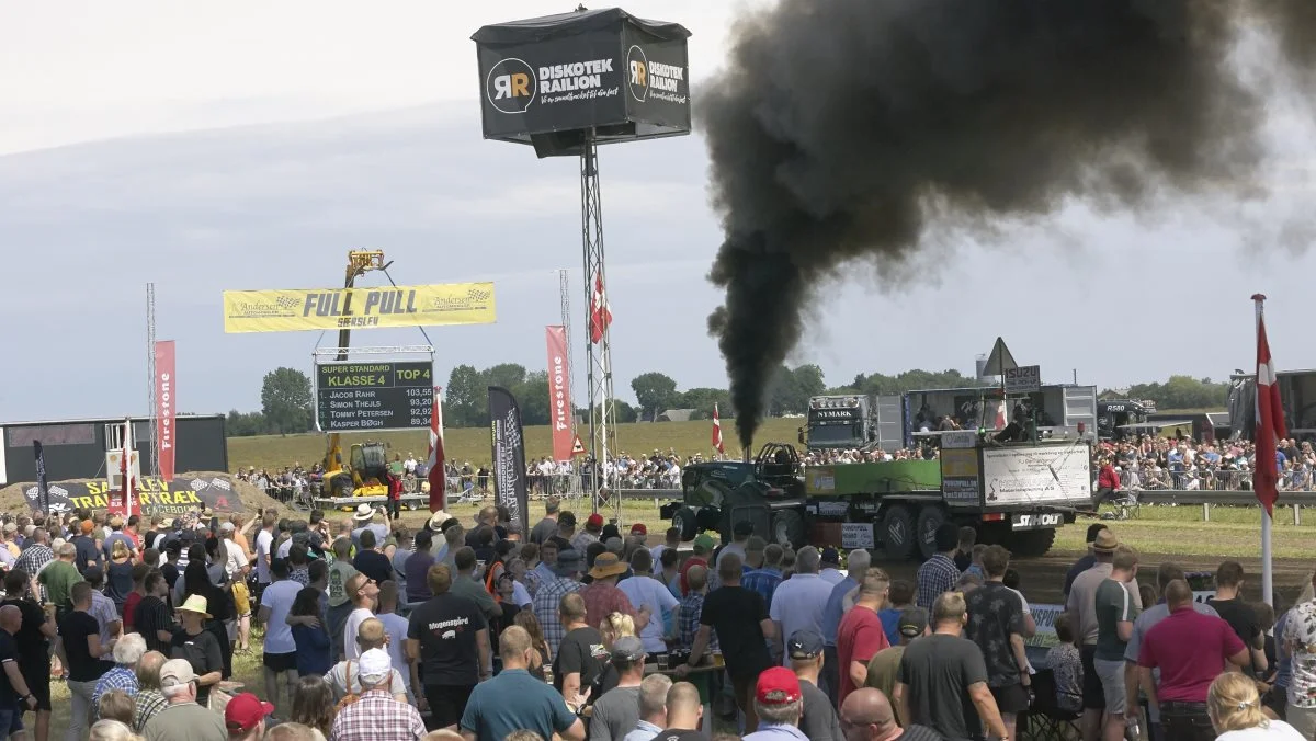De 2.500 hestekræfter fra den modificerede John Deere med navnet Green Matic, der ejes af en familie på en kvæggård i Øster Krarup, lægger et tæt røgslør over det store publikum i Særslev. Fotos: Erik Hansen