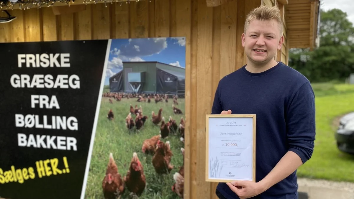 Jens Mogensen foran salgshytten med diplomet fra Agerholms Legat; det synlige bevis for modtagelsen af hæderen og de 10.000 kroner.