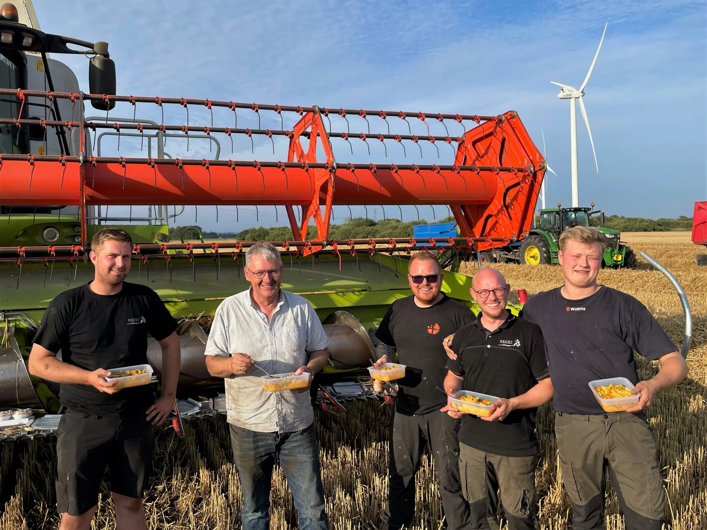 Fra venstre er det Mads Larsen, Per Christensen, Mikkel Christensen, Philip Brinkmann og Emil Søe, der indtager aftensmaden i marken, inden maskinerne startes op i hveden igen. Foto: Niels Brocks Østergaard